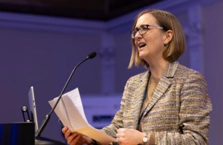 Image of Mairi Gibbs speaking behing a podium at the Oxford-Cambridge Innovation Showcase